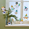 Verschiedene Schneemann-Fensterbilder aus dem Bastelset als Winterdeko am Fenster und auf der Fensterbank arrangiert