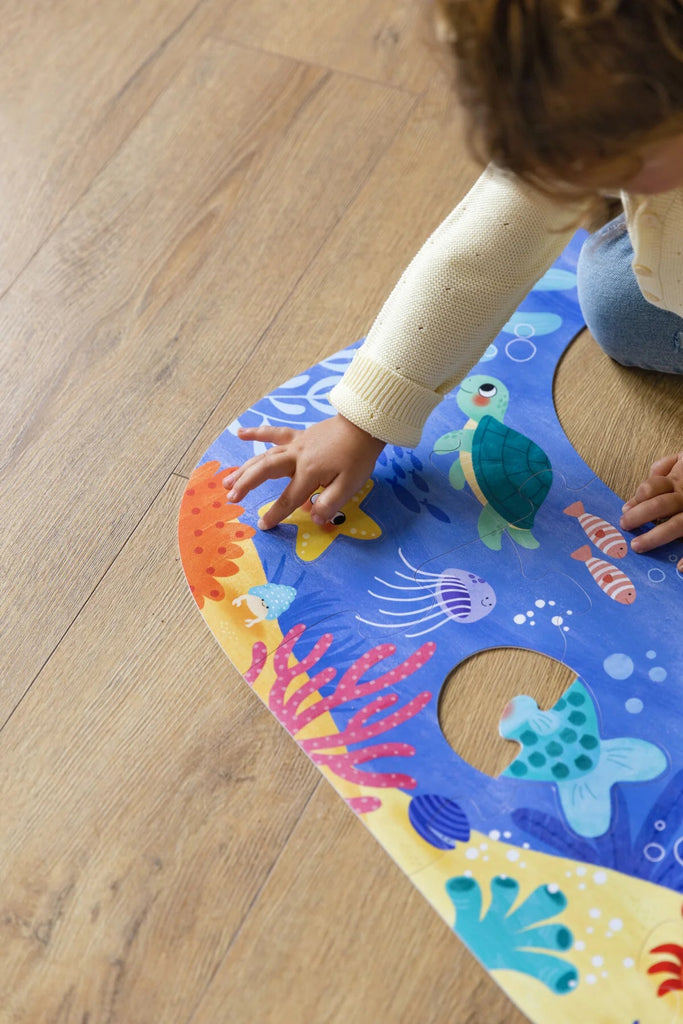 Kind legt Ozeanpuzzle – pädagogisches Spielzeug von Goula
