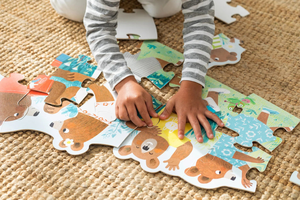 Hände eines Kindes legen Puzzle – Motorikspielzeug ab 2 Jahren
