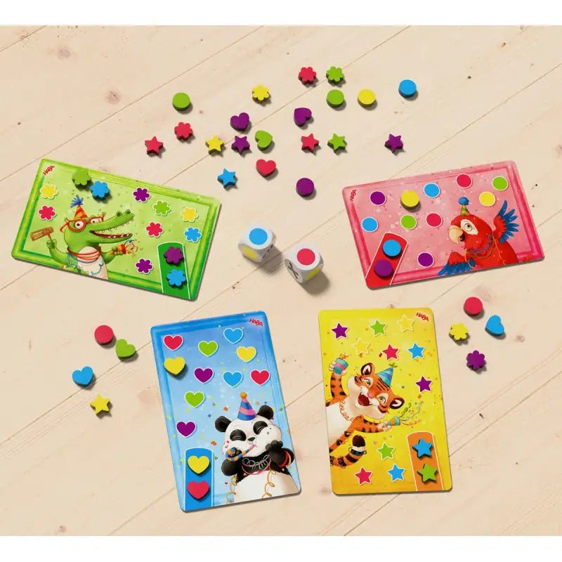 Kinder spielen HABA Hurra mit Würfeln und Konfettiteilen aus Holz
