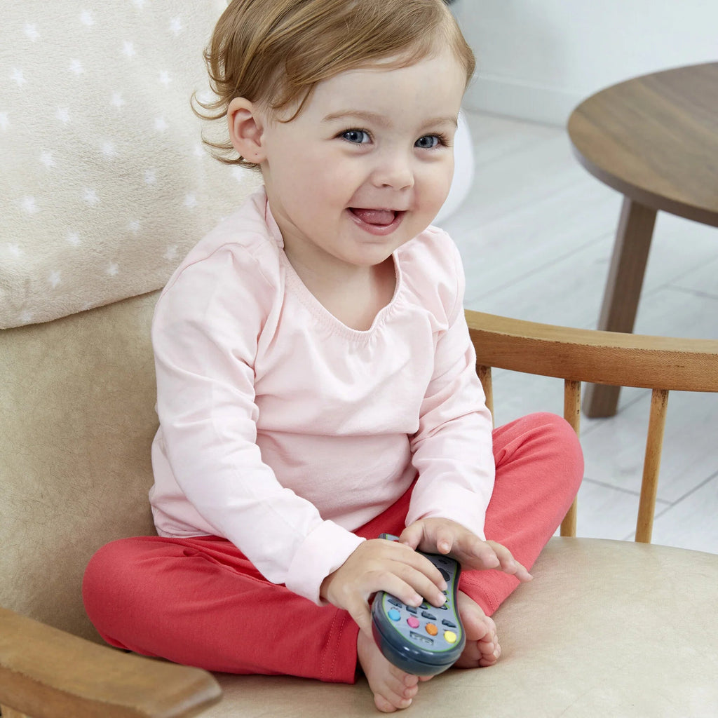 Kind hält Fernbedienung – realistisches Kleinkindspielzeug
