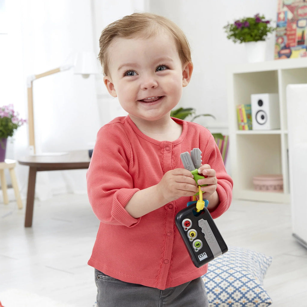 Kind hält Spielzeugschlüssel – realistisches Kleinkindspielzeug
