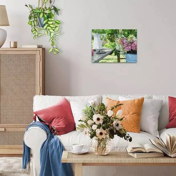 Wohnzimmer mit heller Couch, Pflanzen und an der Wand aufgehängtem fertigen Puzzle "Sommerbunte Löwenmäulchen"