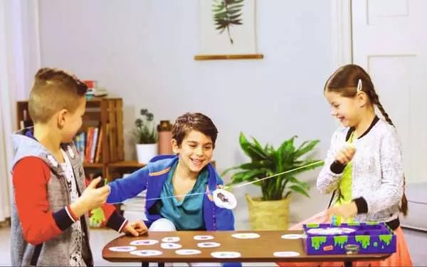 Kinder lachen beim GlibberKlatsch Spiel mit Monsterkarten
